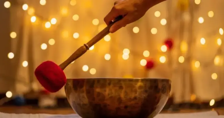 handmade hammered tibetan singing bowl on yellow bokeh background alternative medicine concept 824x434
